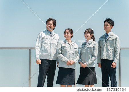 Male and female staff in the manufacturing, building, transportation, and construction industries wearing work clothes. 117339364