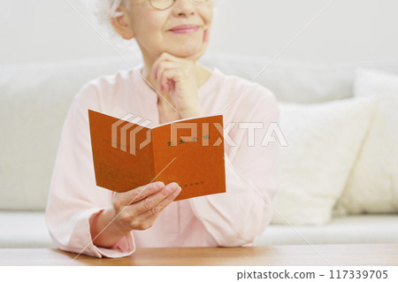 Senior woman holding pension book, no face Senior woman holding pension book, no face 117339705