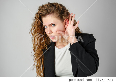 Young Woman Listening With Hand to Ear Young Woman Listening With Hand to Ear 117340685