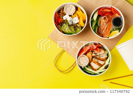 Top view of fresh poke bowls on yellow background Top view of fresh poke bowls on yellow background 117340792
