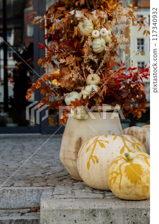 Exterior Beautiful cozy atmospheric halloween pumpkins decorated on porch. Autumn leaves and fall flowers holiday Thanksgiving October season outdoors in city Exterior Beautiful cozy atmospheric halloween pumpkins decorated on porch. Autumn leaves and fall flowers holiday Thanksgiving October season outdoors in city 117340932