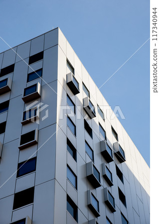 Modern white building with square windows. Multistory apartment building. Minimalistic Stylish living block of flats. Facades of modern office building. Exterior texture pattern Modern white building with square windows. Multistory apartment building. Minimalistic Stylish living block of flats. Facades of modern office building. Exterior texture pattern 117340944