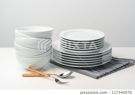 Stylish table setting with white dishware on white tablecloth Stylish table setting with white dishware on white tablecloth 117340976