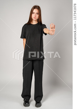 Young Woman Gesturing Stop With Her Hand in a Studio 117341078