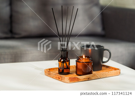 Aromatic reed freshener and candle on table in room 117341124