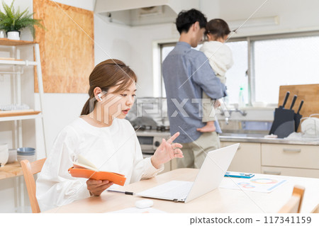 A wife working remotely while her husband looks after the children 117341159