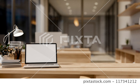 A laptop computer mockup and decor on a wooden table in a contemporary business office. 117341212