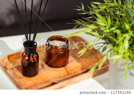 Aromatic reed freshener and candle on table in room Aromatic reed freshener and candle on table in room 117341240