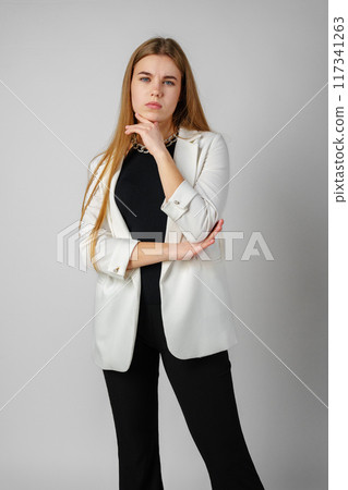 Young Woman Expressing Discontent against gray background 117341263