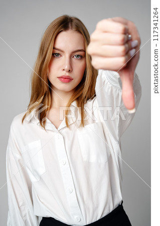 Young Woman in White Shirt Pointing Finger Down Dislike Young Woman in White Shirt Pointing Finger Down Dislike 117341264