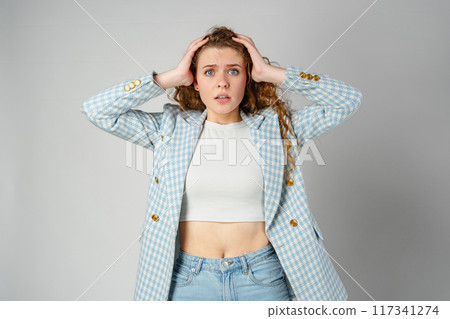 Young Businesswoman Gesturing Excitement or Surprise Against a Neutral Background 117341274