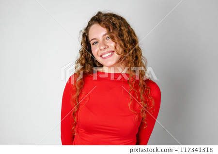 Young Woman With Curly Hair Portrait against gray background Young Woman With Curly Hair Portrait against gray background 117341318