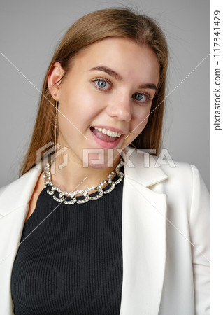 Woman in Black Top and White Jacket Posing in Studio Woman in Black Top and White Jacket Posing in Studio 117341429