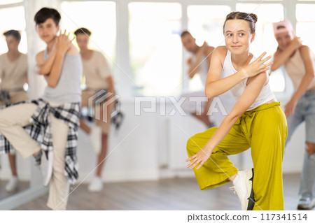 Teen girl with group of teenage friends, learn to dance hip hop Teen girl with group of teenage friends, learn to dance hip hop 117341514
