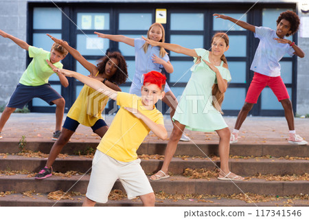 Children exercising contemporary dance moves outdoors Children exercising contemporary dance moves outdoors 117341546