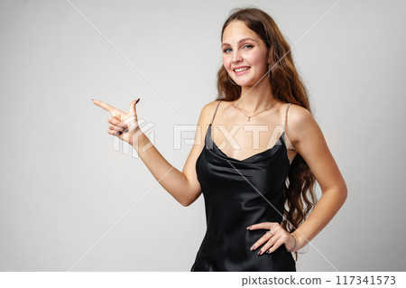 Woman in Black Dress Pointing at Something 117341573