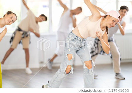 Group of girls an boys perform choreographic exercises and teaches energetic breakdancing waacking together Group of girls an boys perform choreographic exercises and teaches energetic breakdancing waacking together 117341603