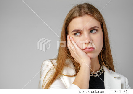 Young Woman Expressing Discontent against gray background Young Woman Expressing Discontent against gray background 117341743