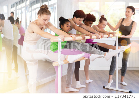 Group of teenage dancers practicing stretching at barre 117341775