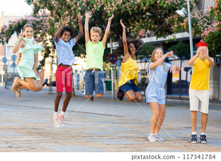 Group of cheerful young girls and boys jumping together Group of cheerful young girls and boys jumping together 117341784