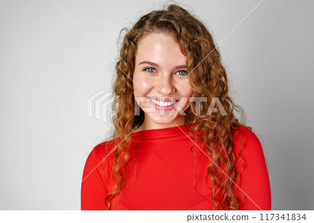Young Woman With Curly Hair Portrait against gray background Young Woman With Curly Hair Portrait against gray background 117341834