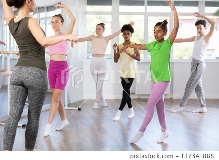 Teenage African American girl practicing ballet moves at group class Teenage African American girl practicing ballet moves at group class 117341888