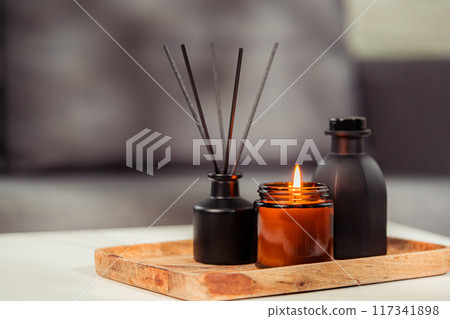 Aromatic reed freshener and candle on table in room Aromatic reed freshener and candle on table in room 117341898