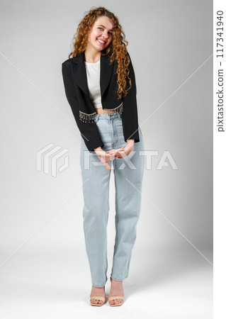Young Woman With Curly Hair Portrait against gray background Young Woman With Curly Hair Portrait against gray background 117341940