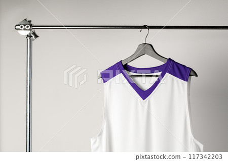 White basketball jersey hanging against white background White basketball jersey hanging against white background 117342203
