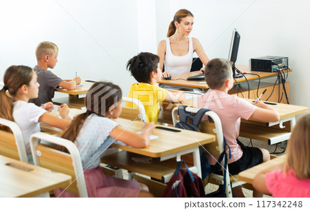 Schoolchildren in classroom 117342248