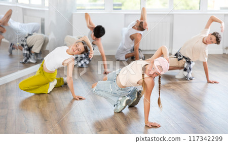 Teenage girl dancing breakdancing in group Teenage girl dancing breakdancing in group 117342299