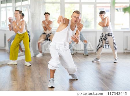 Young guy dancing hip-hop against background of group members 117342445