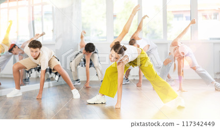 Teenage girl practicing hip-hop dance in training hall 117342449