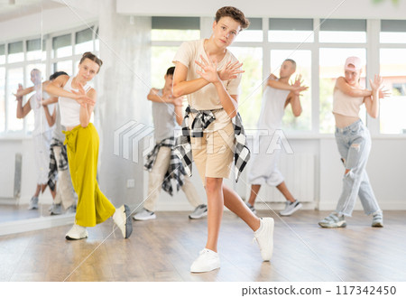 Teenage boy practicing basic hip hop moves in training hall 117342450
