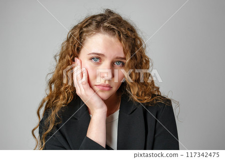 Young Woman With Curly Hair Expressing Concern 117342475