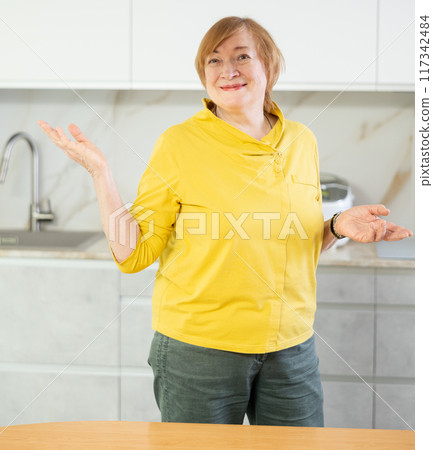 Portrait of a smiling mature woman in the kitchen Portrait of a smiling mature woman in the kitchen 117342484