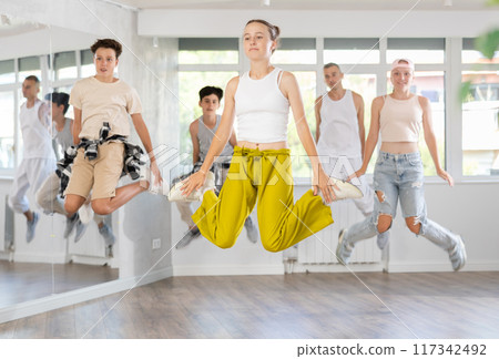 Teenagers jumping at street dance and hip hop classes Teenagers jumping at street dance and hip hop classes 117342492