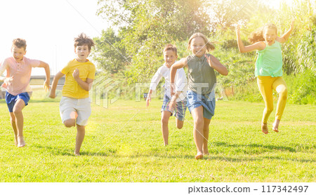 Group of five happy children jogging in a park Group of five happy children jogging in a park 117342497