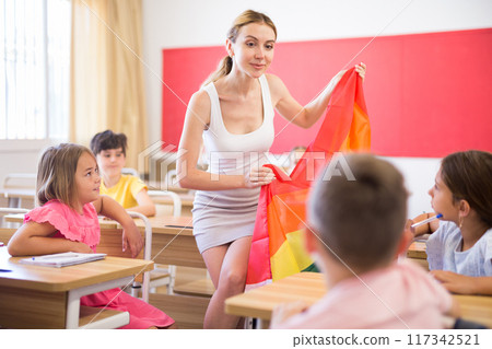 Smiling female teacher talking with tweens about LGBT at lesson Smiling female teacher talking with tweens about LGBT at lesson 117342521