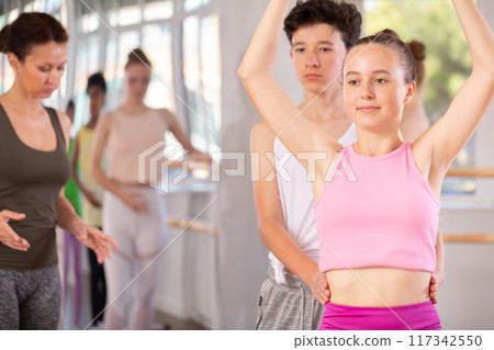 Teenage girl and boy practicing ballet moves in pair in dance studio 117342550