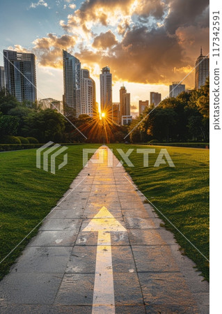 Pathway through Park Leading to City Skyline at Sunrise 117342591