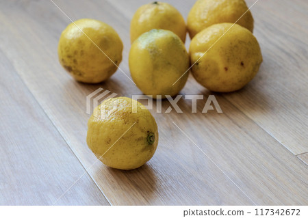 Yellow lemons on a wooden table 117342672