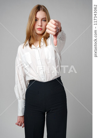 Young Woman in White Shirt Pointing Finger Down Dislike 117343062