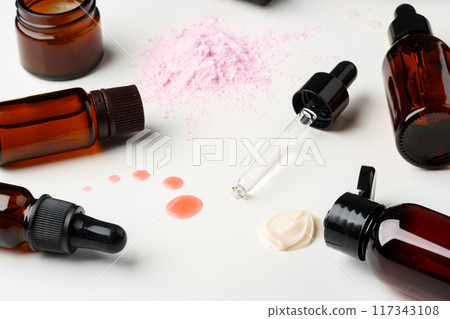 Assorted Skincare Products and Powder Spilled on a White Background Assorted Skincare Products and Powder Spilled on a White Background 117343108