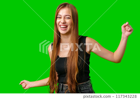 Young Woman With Long Brown Hair Laughing and Dancing in Front of Green Screen Young Woman With Long Brown Hair Laughing and Dancing in Front of Green Screen 117343228