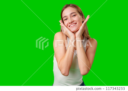 Young Woman Smiling With Hands on Cheeks Against Green Screen Background 117343233