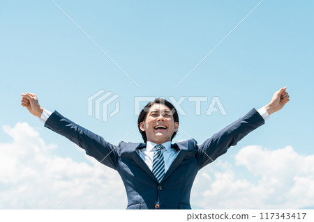Young Asian businessman shouting in the blue sky (change job, win, get a job, quit your job, challenge, work hard, achieve) 117343417