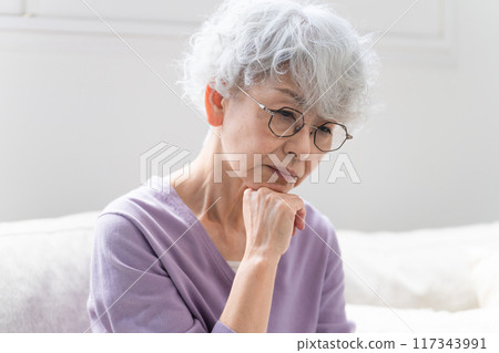 Senior woman sitting on sofa 117343991