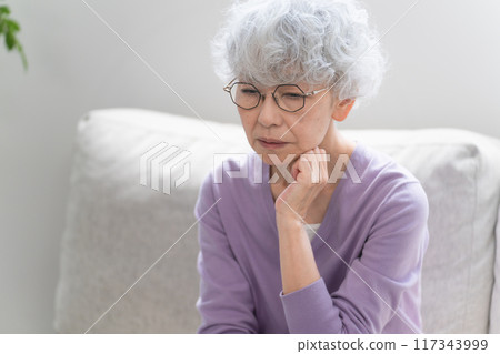 Senior woman sitting on sofa Senior woman sitting on sofa 117343999