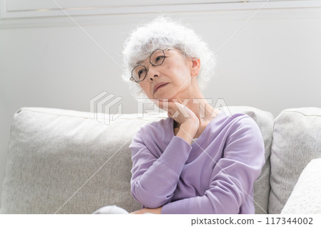 坐在沙發上的老年婦女 坐在沙發上的老年婦女 117344002